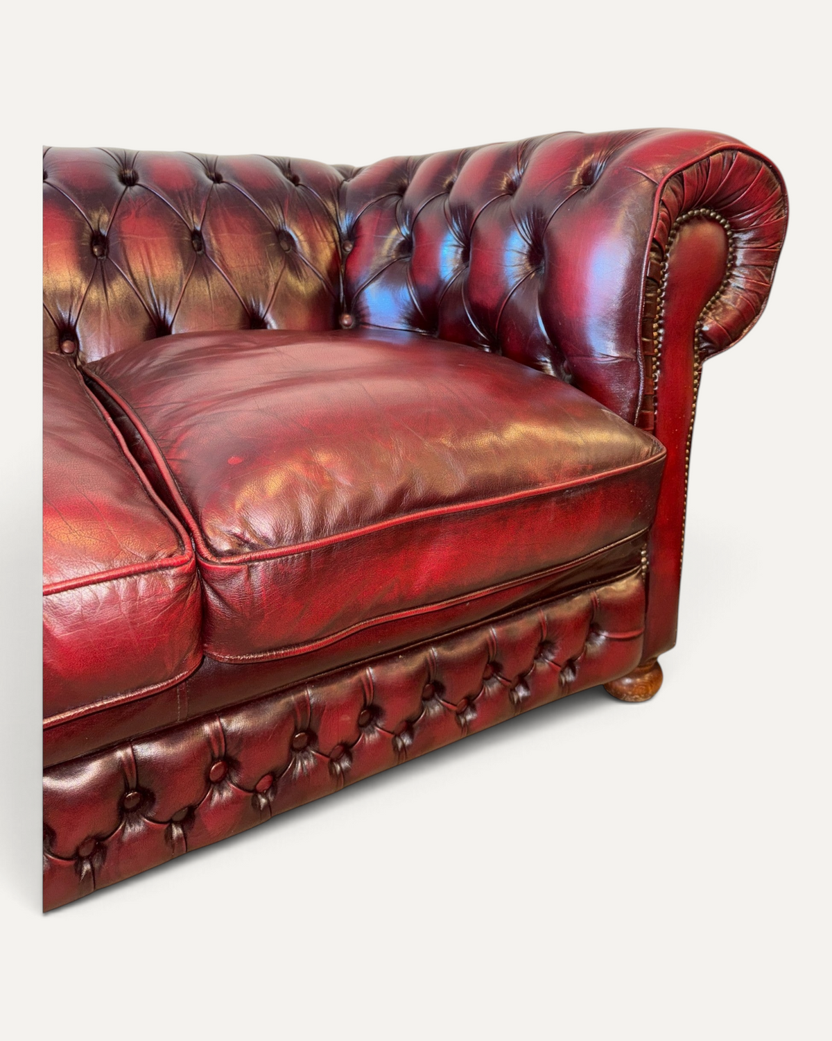 Chesterhome vintage 3-seater Chesterfield sofa in oxblood leather with button tufting, rolled arms, and brass studs.