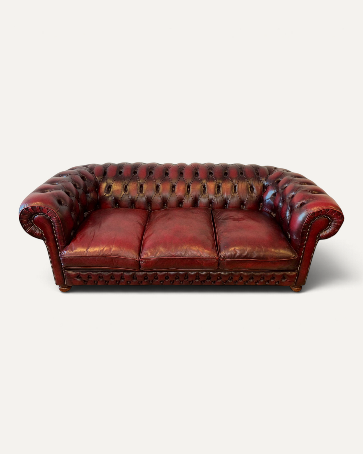 Chesterhome vintage 3-seater Chesterfield sofa in oxblood leather with tufted back, rolled arms, and brass nailheads.