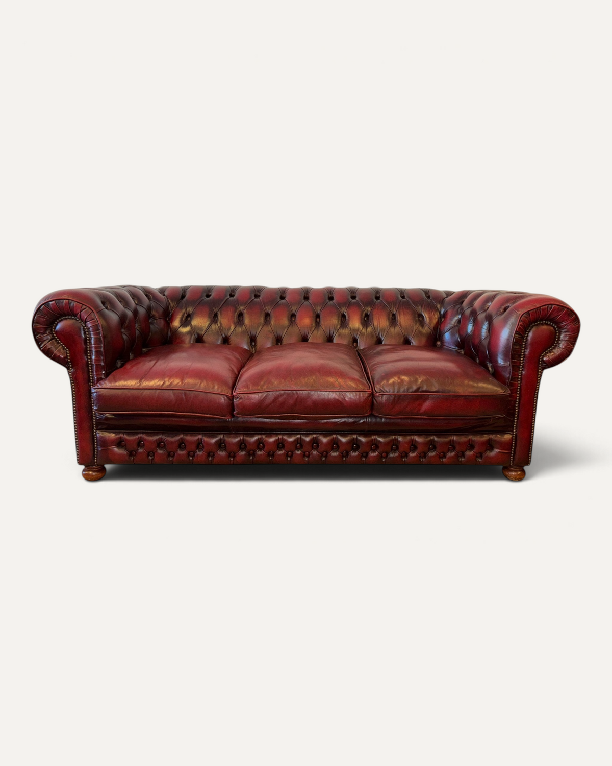 Chesterhome vintage 3-seater Chesterfield sofa in oxblood leather with deep button tufting and brass nailhead trim.